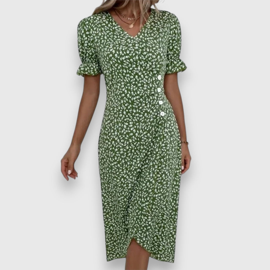 Green floral dress with gathered sleeves and buttons, woman posing, studio setting.