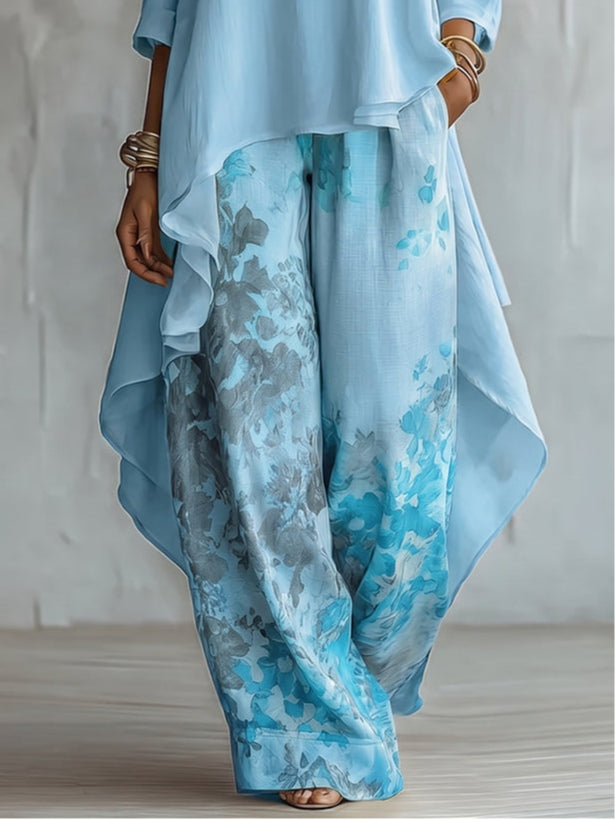 Detailed view of light blue floral pants and a cascading top edge, against a studio backdrop.