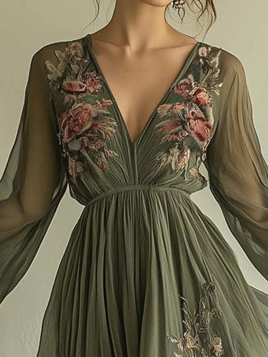 Close-up of elegant chiffon dress bodice in olive green with intricate floral embroidery and deep V-neck indoors.