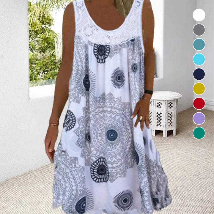 Woman in white printed dress in a bright room with window view of greenery.