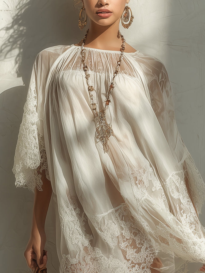 Close-up of sheer white mini dress with lace patterns, accessorized with large earrings and necklace.