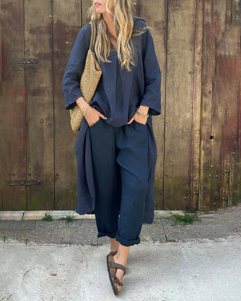 Woman in navy chic and comfortable set with woven bag by rustic wooden wall.