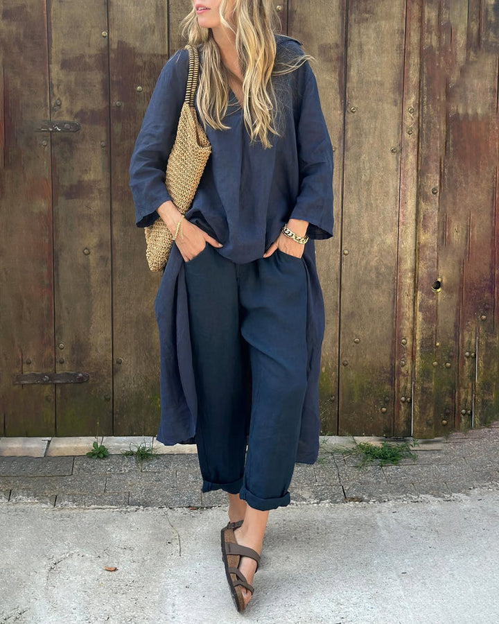 Woman in navy chic and comfortable set with woven bag by rustic wooden wall.