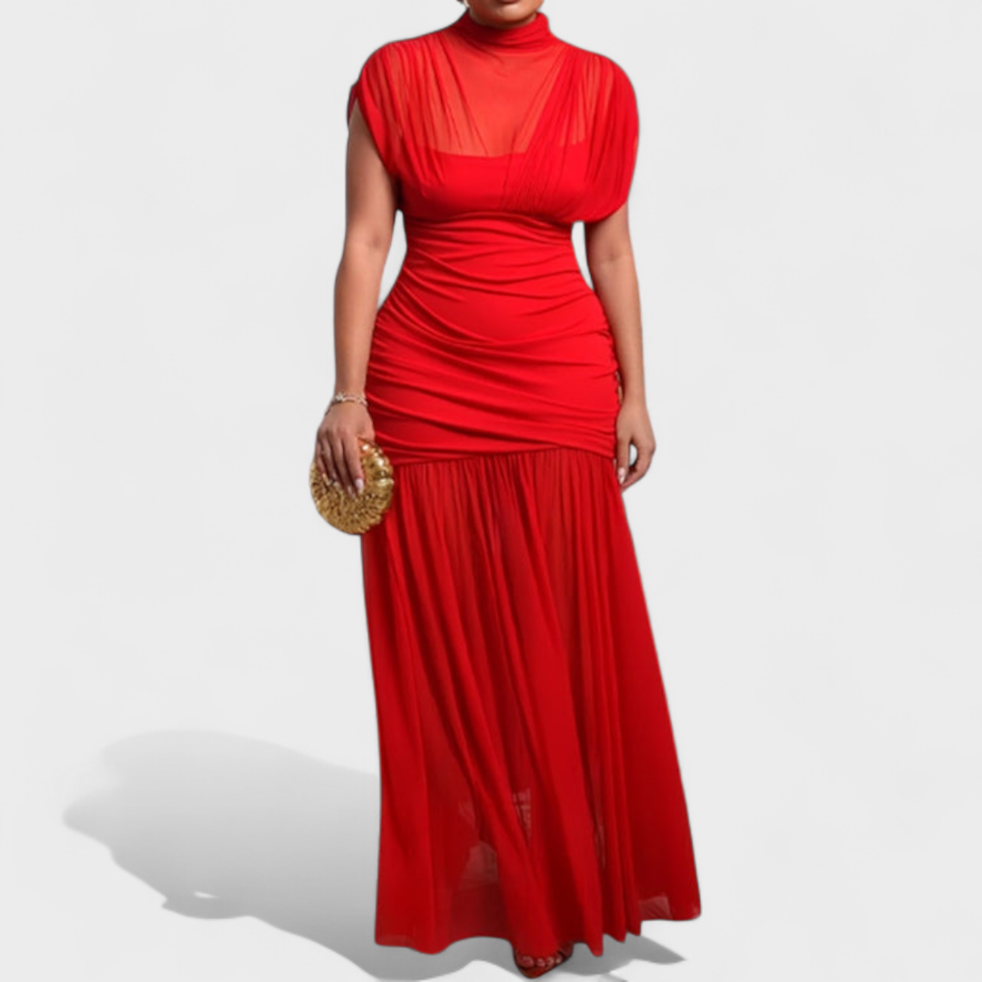 Striking red dress with sheer neckline and flowing skirt, held by a model in a studio.