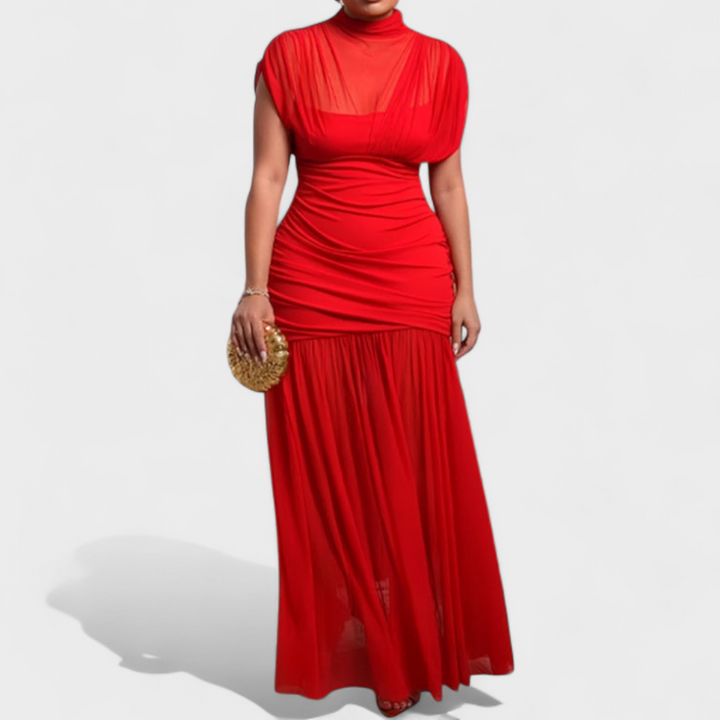 Striking red dress with sheer neckline and flowing skirt, held by a model in a studio.