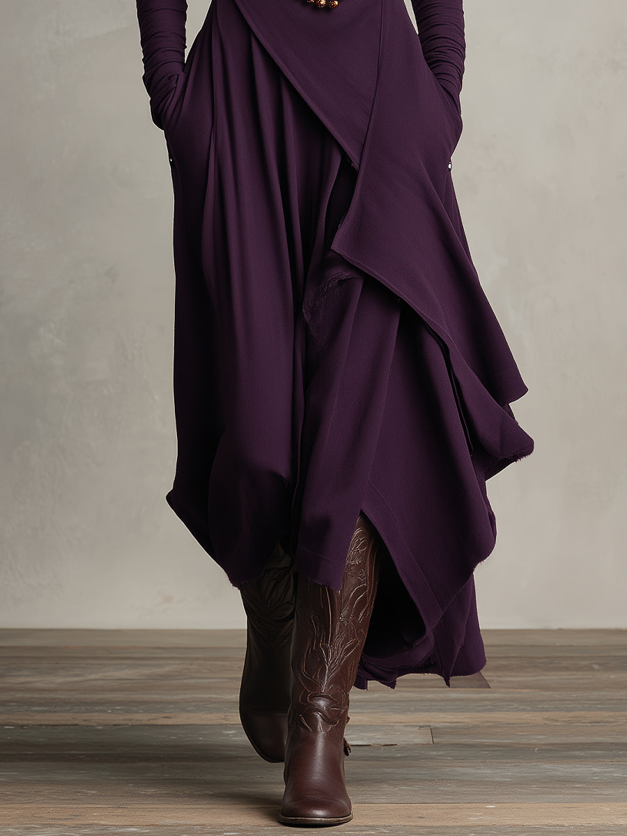 Focus on the hem and boots with trailing layers of a purple stretch maxi dress, in a studio setting.