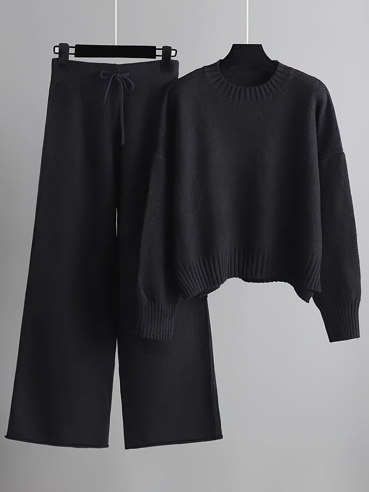 Dark gray knit loungewear set featuring a comfy sweater and wide-leg pants on hangers, gray background.