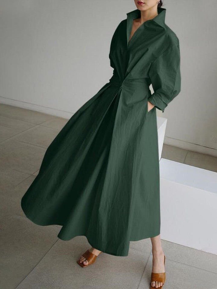 Olive green midi dress with button lapel, worn indoors with slight movement captured.