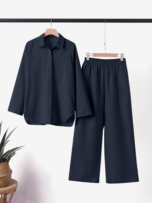 Deep blue two-piece outfit on a hanger in a well-lit room, adjacent to a wicker plant basket.