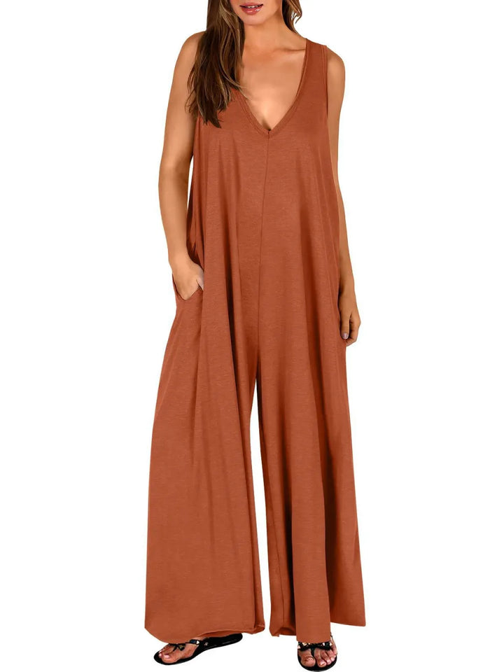 Rust-colored V-neck jumpsuit with wide legs, modeled in a studio with a white background.
