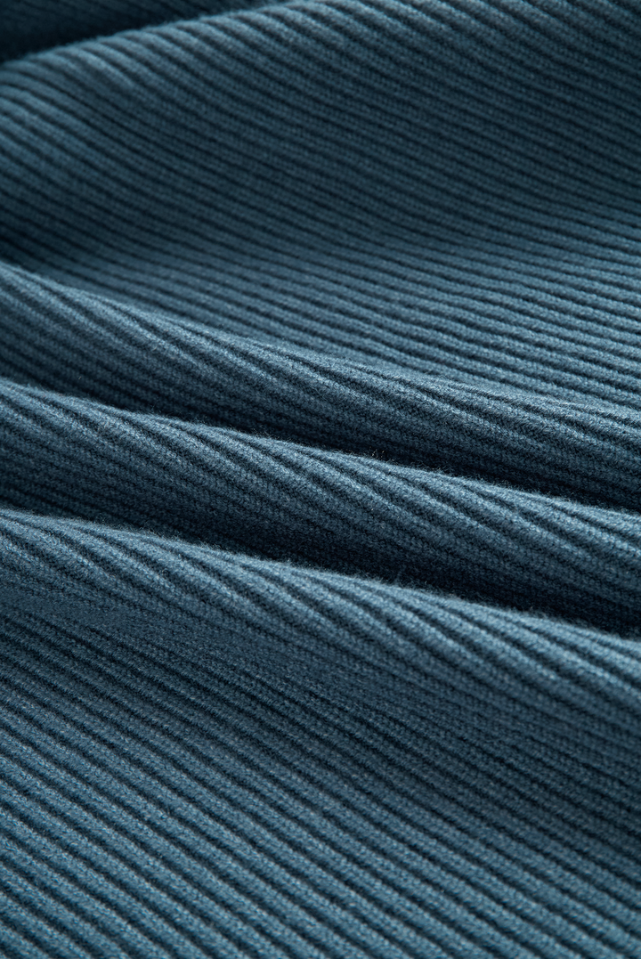 Detailed view of blue ribbed-knit fabric from a maxi dress, showcasing texture and weave.
