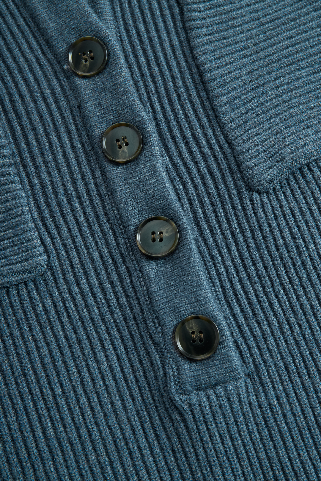 Close-up of blue ribbed knit with four buttons on a maxi dress.