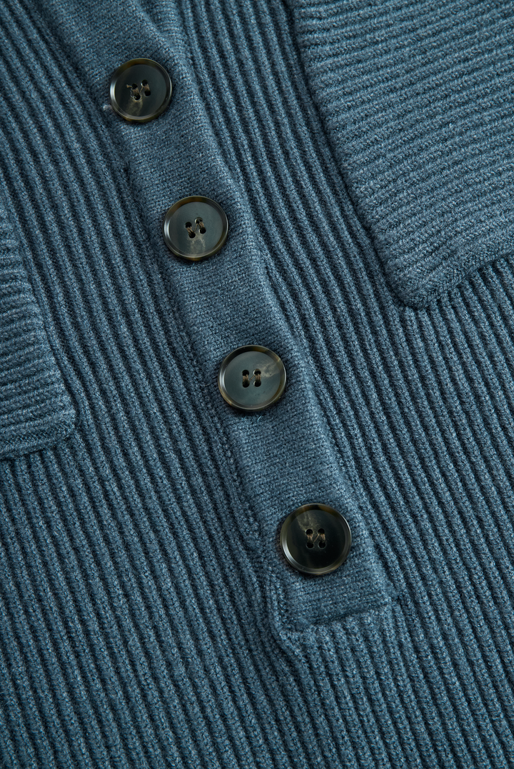 Close-up of blue ribbed knit with four buttons on a maxi dress.