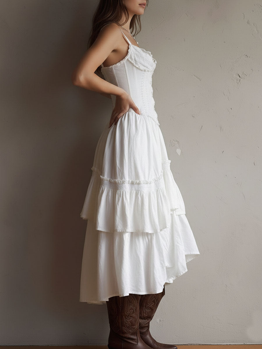 Side view of white midi dress with tiered ruffles, brown boots. Neutral background.