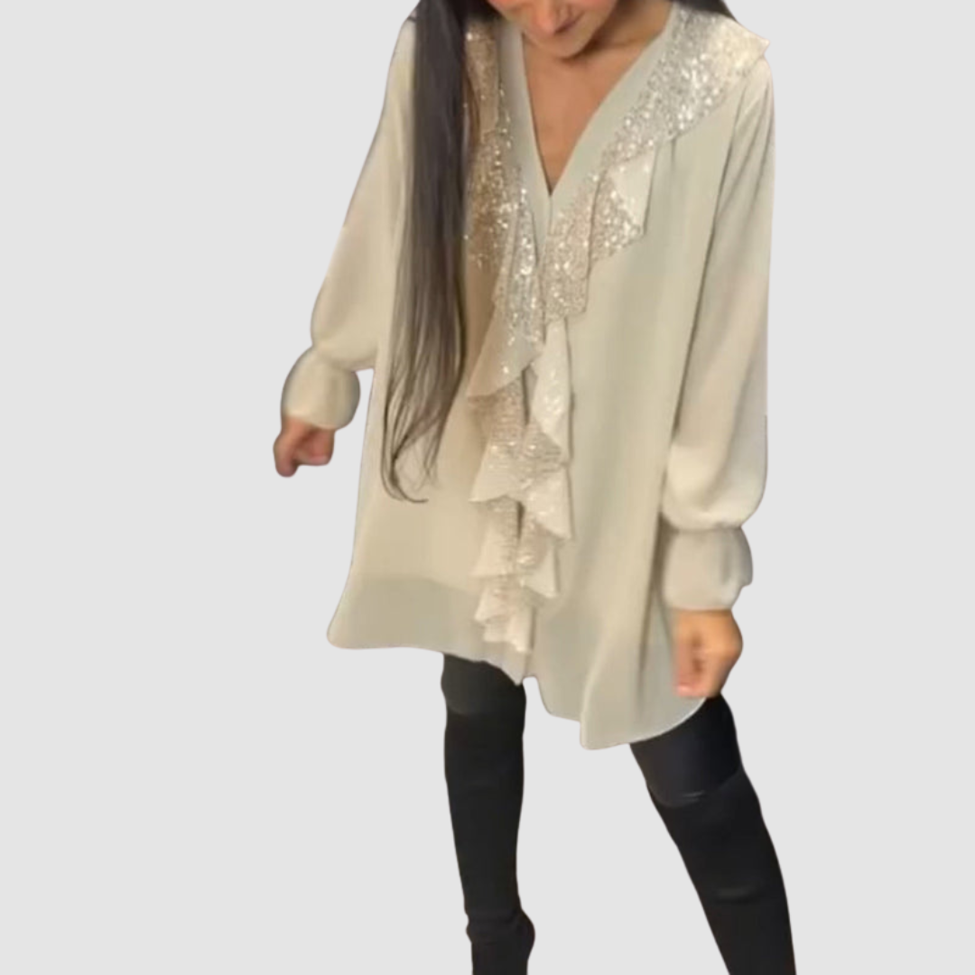 Light beige blouse with ruffled sparkle accents, styled with leggings in a studio setting.