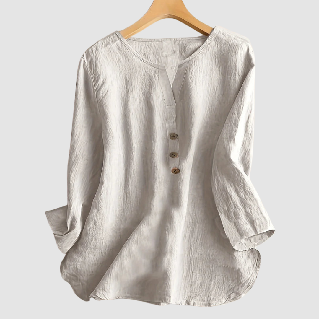Beige casual blouse with button detail displayed on a hanger against a plain background.