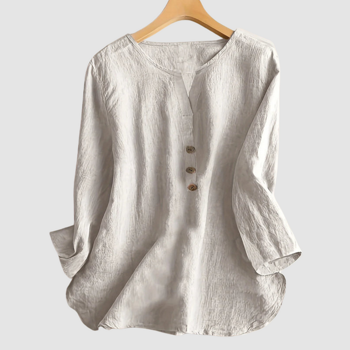 Beige casual blouse with button detail displayed on a hanger against a plain background.