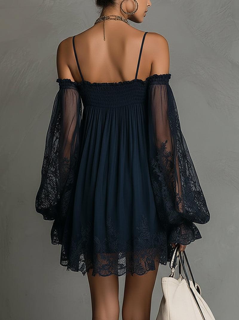 Back view of navy off-shoulder dress featuring lace sleeves and hem, paired with a white tote in studio setting.