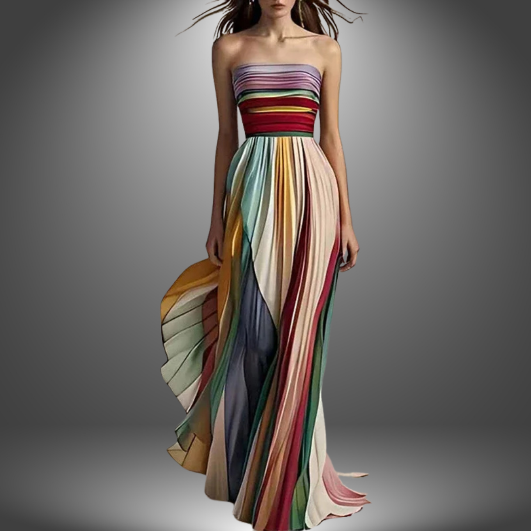 Model wearing a strapless, multicolored, pleated long dress in a studio with a gradient background.