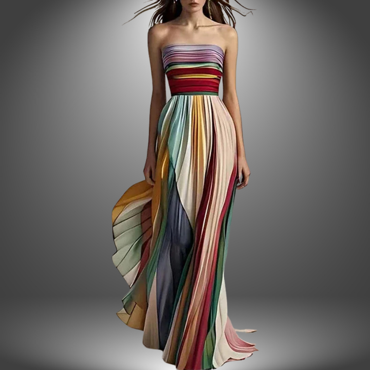 Model wearing a strapless, multicolored, pleated long dress in a studio with a gradient background.