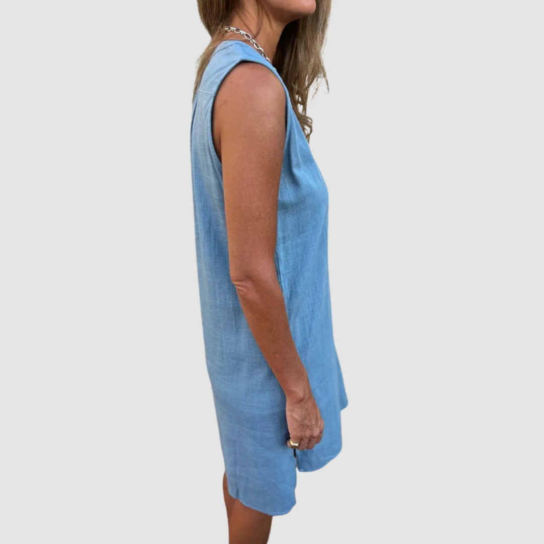 Side profile of a woman in a blue sleeveless dress, showing the dress&