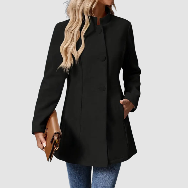 Black jacket with large buttons, model side view, holding clutch, against plain background.