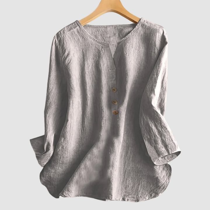 Grey casual blouse with button detail displayed on a hanger against a plain background.