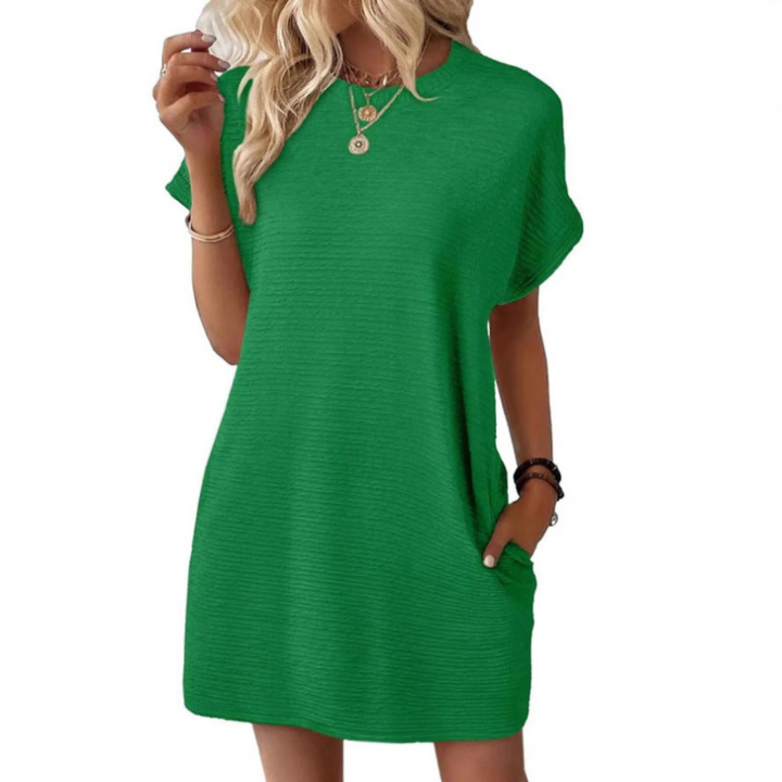 Bright green casual dress with short sleeves and a relaxed fit, styled with layered necklaces in a studio setting.
