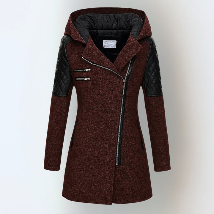 Deep red hooded winter jacket with black quilted shoulders and asymmetrical zipper, studio background.