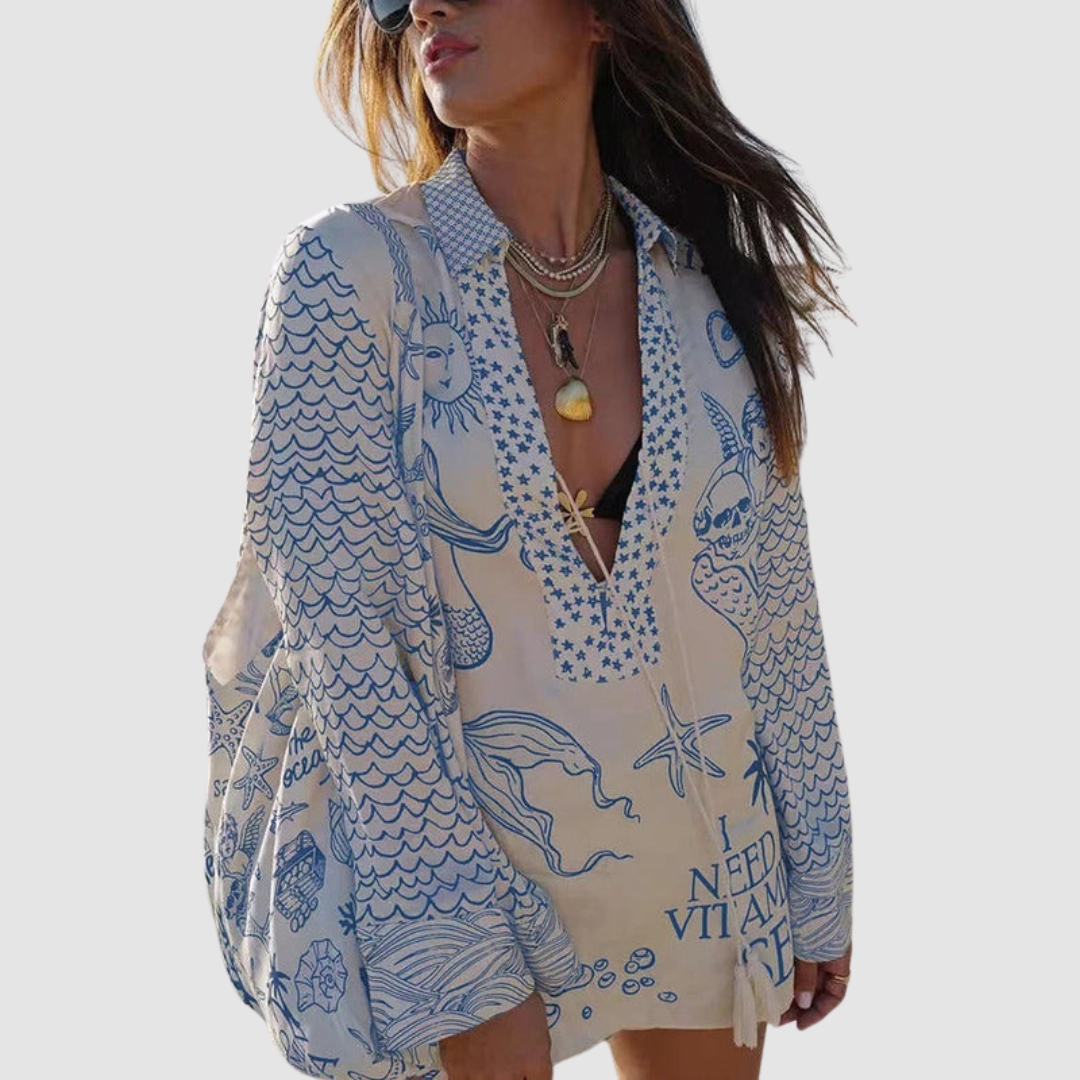 Model in blue decorated two-piece set, grey background.
