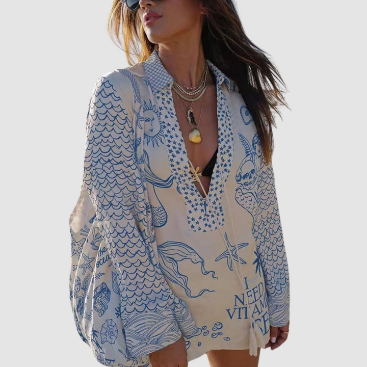 Model in blue decorated two-piece set, grey background.