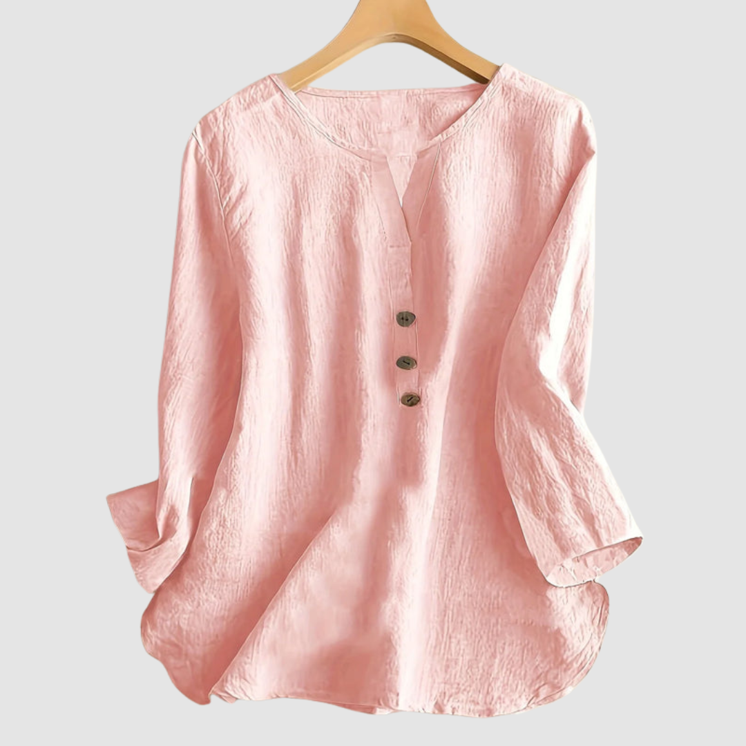 Pink casual blouse with button detail displayed on a hanger against a plain background.