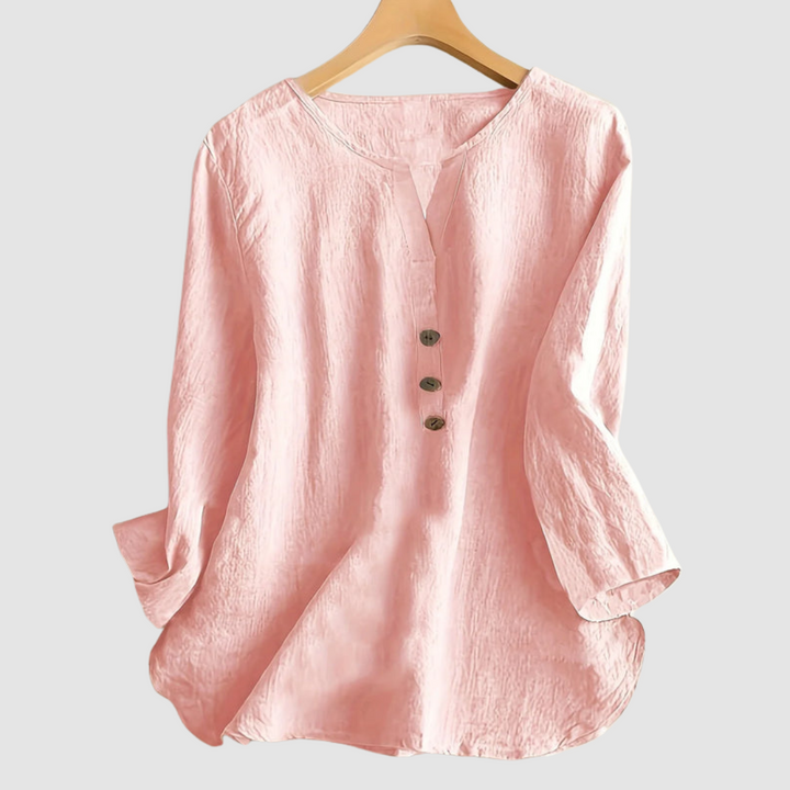Pink casual blouse with button detail displayed on a hanger against a plain background.