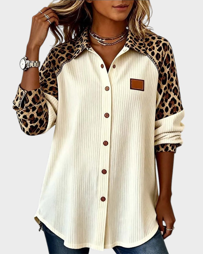 Leopard print button-down shirt in cream with brown buttons. Patterned collar and sleeves. Worn by model in a studio.