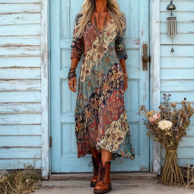 Flowy printed maxi dress in an eclectic pattern, styled outdoors beside a weathered blue door with hanging decor.