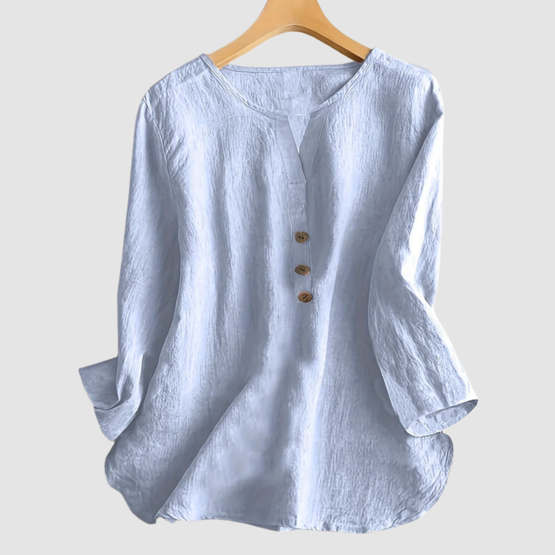 Light blue casual blouse with button detail displayed on a hanger against a plain background.