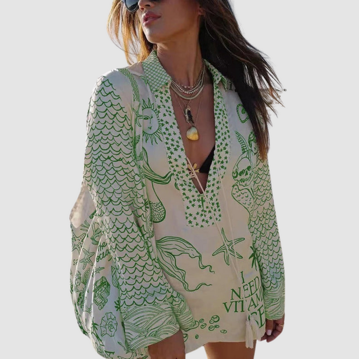 Model in green designed two-piece set, grey background.
