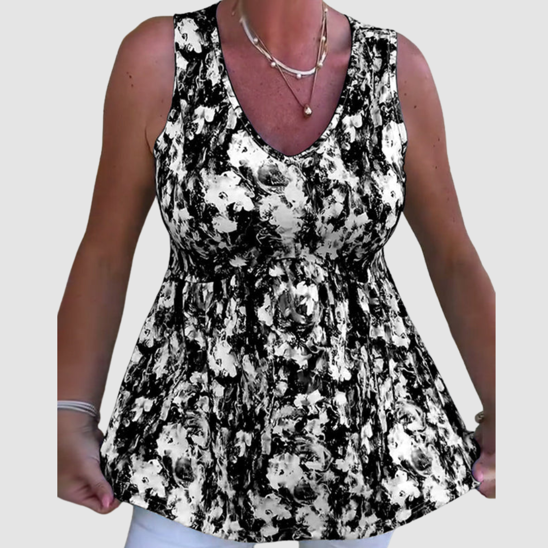Close-up of a woman wearing a black and white abstract patterned sleeveless top in a studio setting.