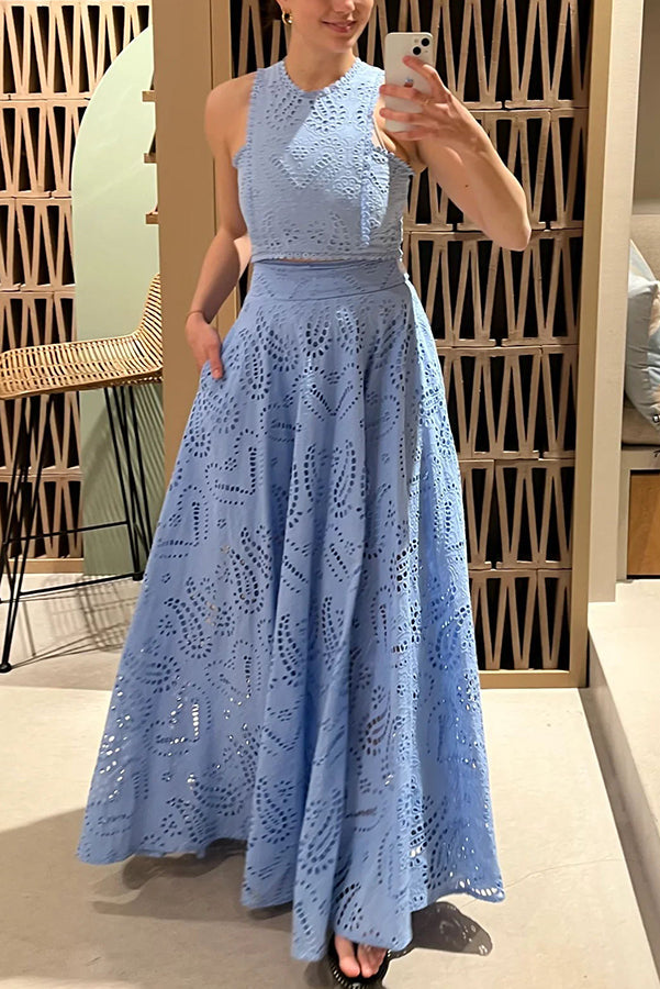 Person taking a mirror selfie in a blue embroidered top and high-waist maxi skirt inside a stylish room.