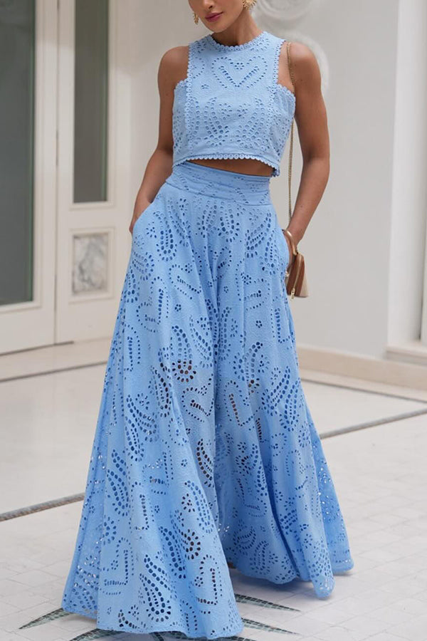 Model wearing a blue embroidered top and high-waist maxi skirt set in an elegant indoor setting.