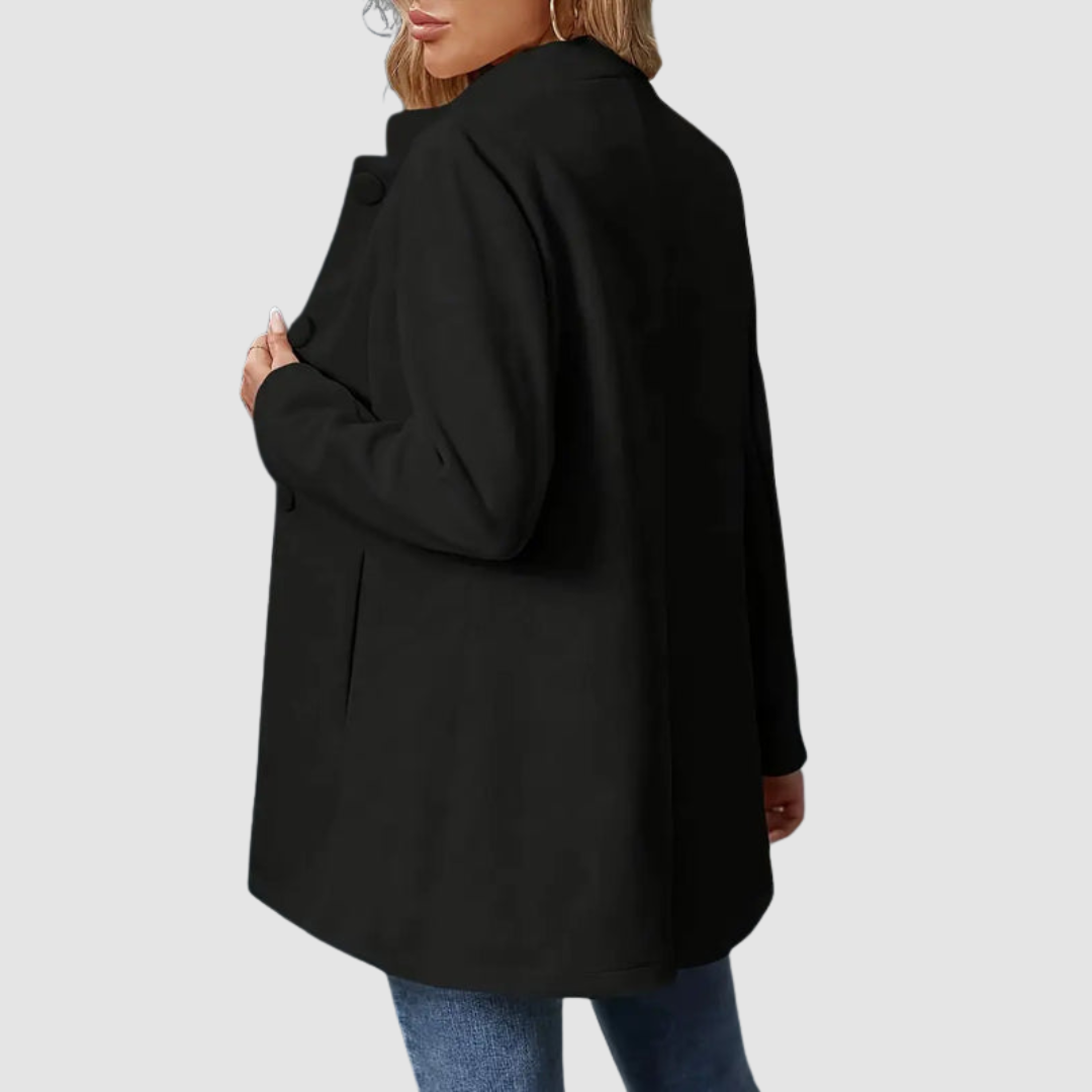 Back view of black jacket with large buttons, worn over jeans, against a plain background.