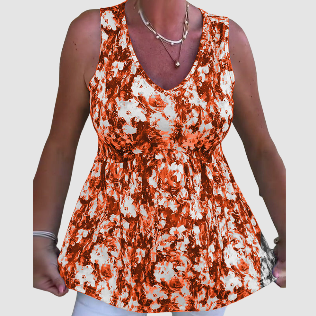 Woman wearing a sleeveless top with an orange and white abstract pattern in a studio setting.