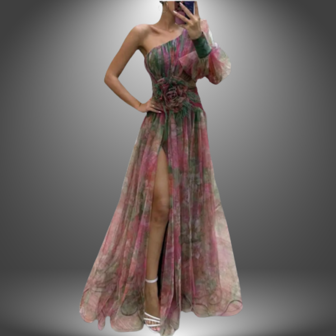Green and pink elegant dress featuring a one shoulder style, floral waist detail, and side slit against a gradient studio background.