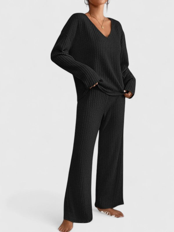 Black ribbed V-neck long-sleeve top and matching wide-leg pants in studio setting.