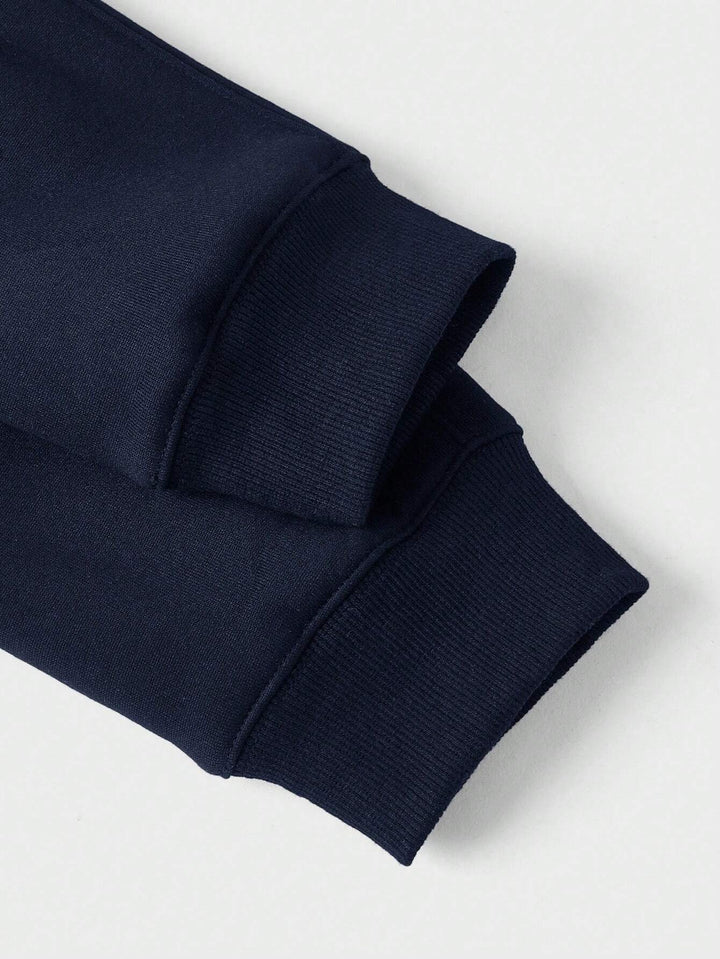 Close-up of navy blue sweater cuffs, displaying ribbed texture and stitching.