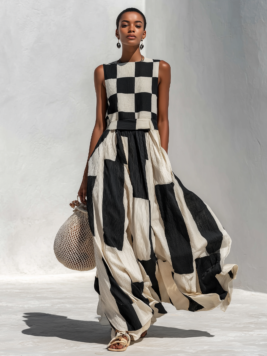 Front view of a model in a black and white checkered sleeveless maxi dress, holding a crochet bag, on a light textured floor.