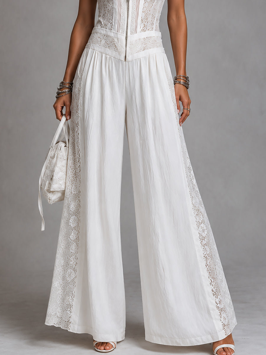 Close-up of white wide-leg jumpsuit with lace trim, studio backdrop.