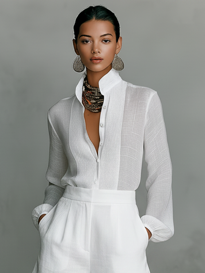 Close-up of white high-collar shirt and top half of shorts in a studio setting.