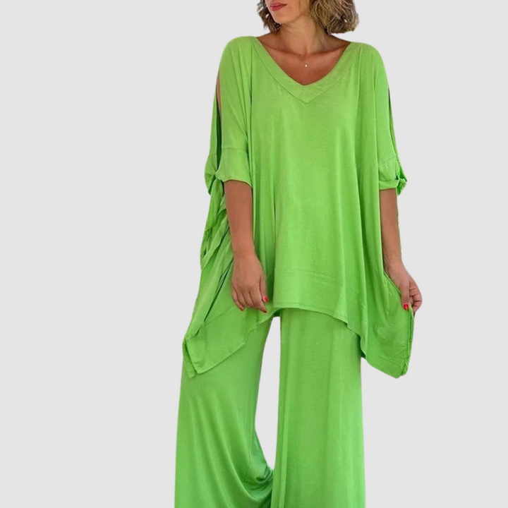 Woman dressed in a bright green relaxed style set with a comfortable top and wide-leg pants, in a studio environment.