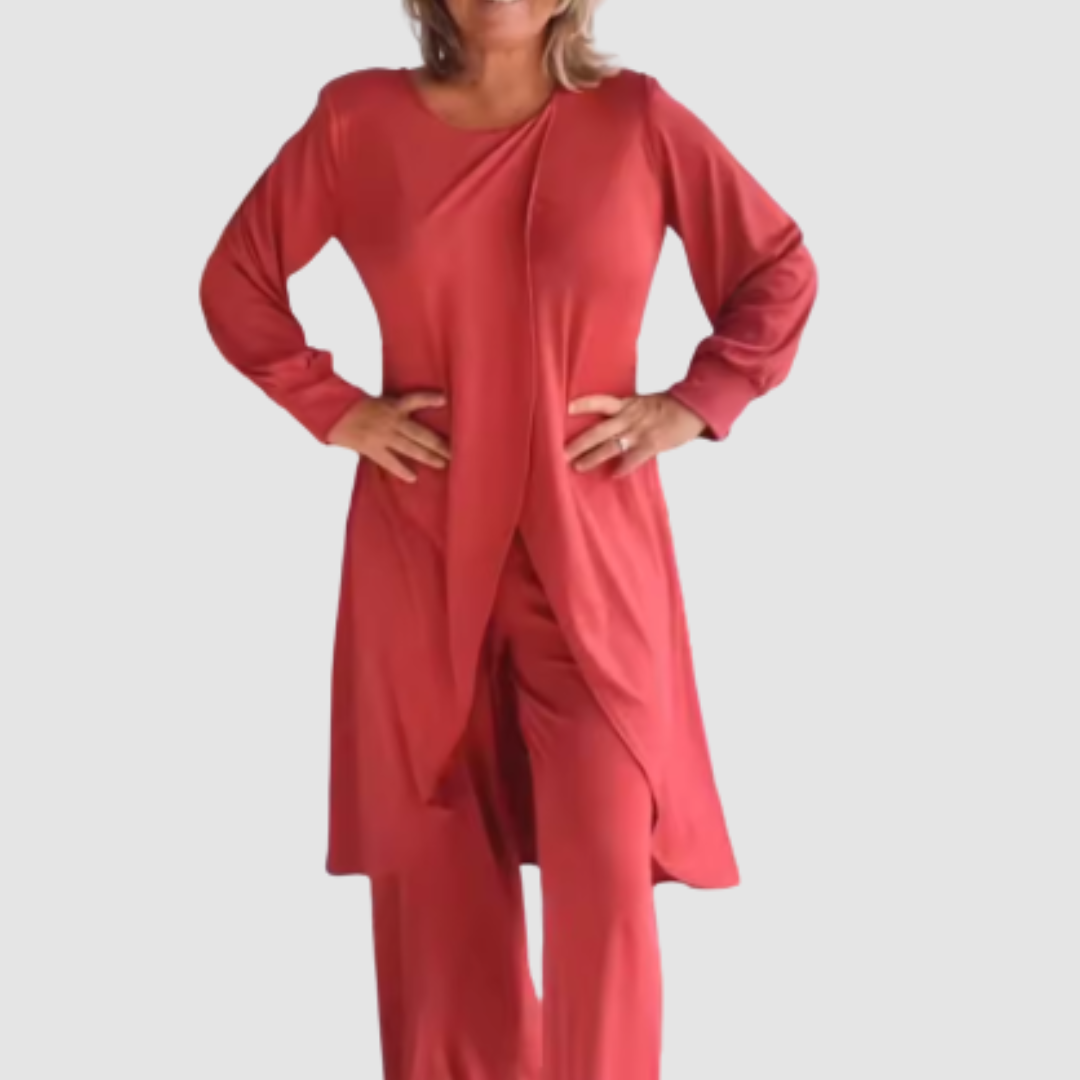 Model wearing a red long-sleeve 2-piece set in a studio, hands on hips, white background.